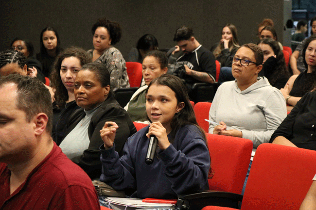 Alunos reunidos no auditório para palestra sobre IA e Negócios.